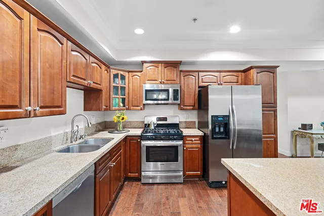 a kitchen with stainless steel appliances granite countertop a refrigerator stove and sink
