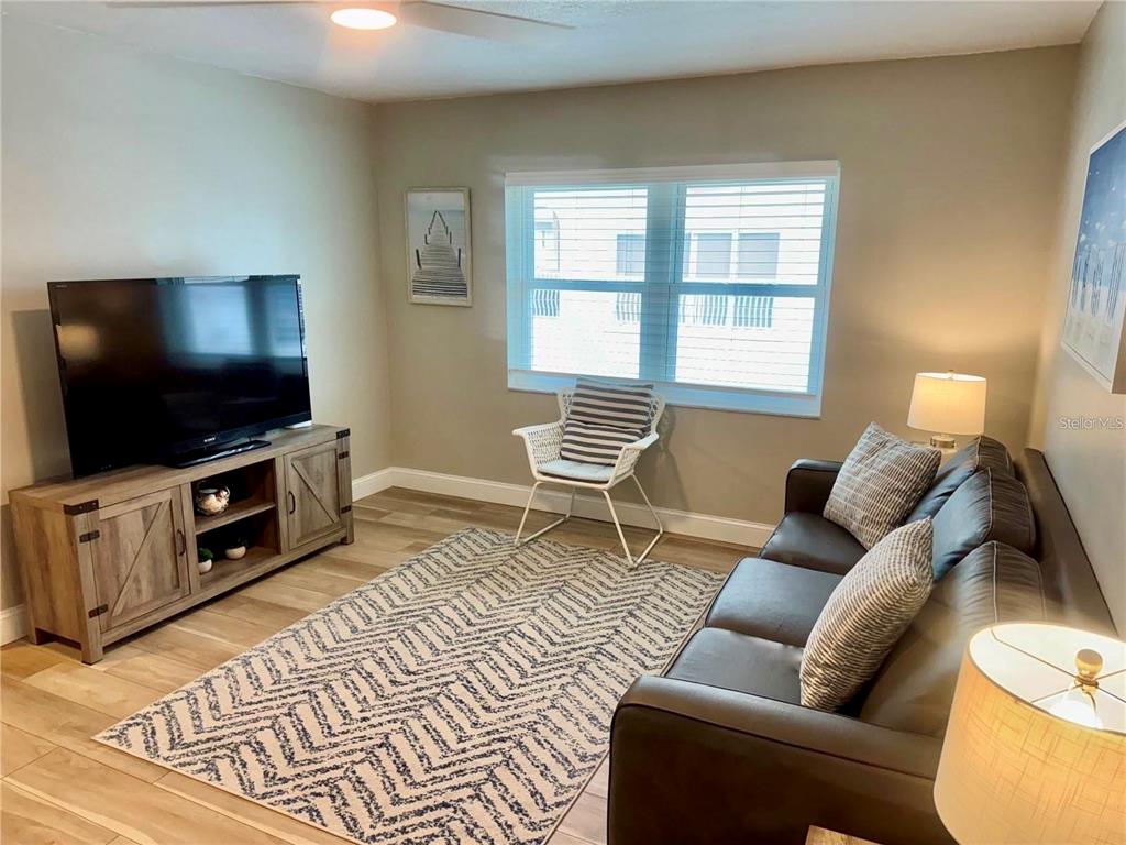 10 164th Avenue, Unit 11 Redington Beach, FL 33708 - Photo 12 of 30 a living room with furniture and a flat screen tv
