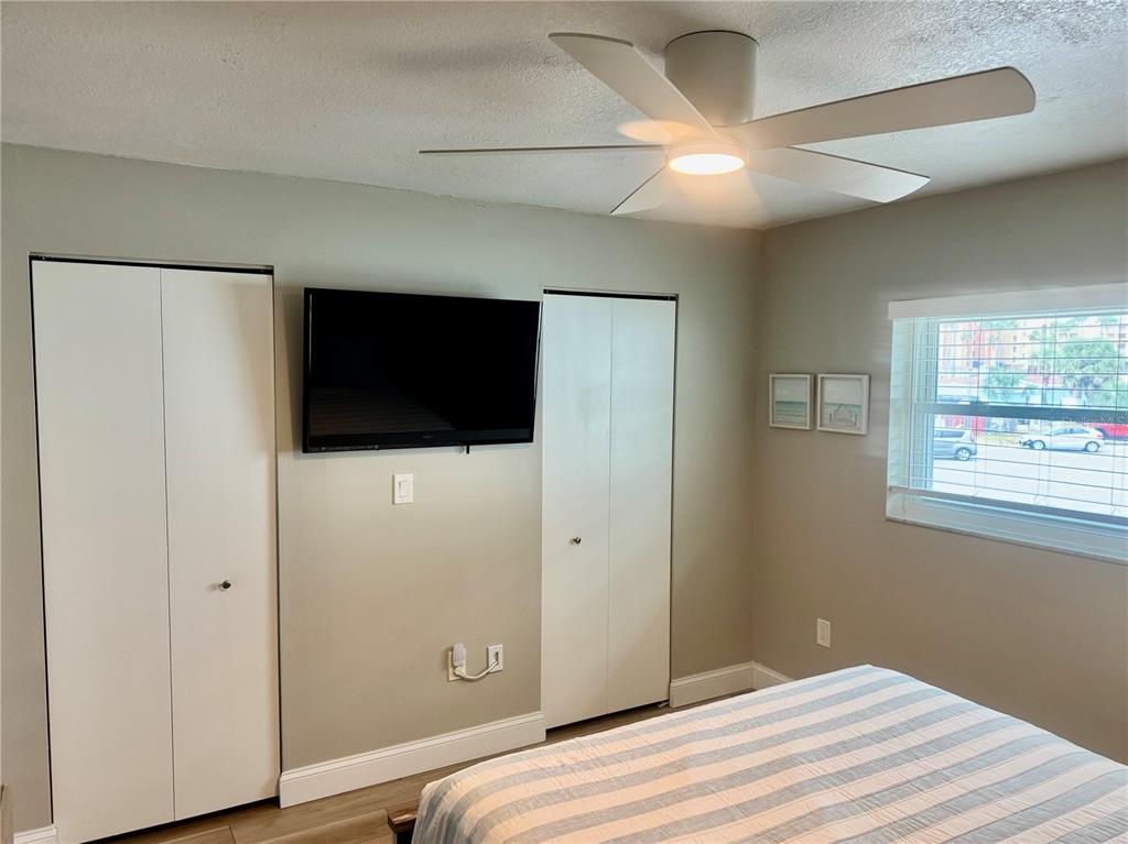 10 164th Avenue, Unit 11 Redington Beach, FL 33708 - Photo 22 of 30 a bedroom with a bed and a flat screen tv