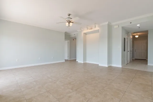 a view of a big room with windows and chandelier fan