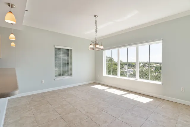 a view of a big room with a chandelier fan and kitchen view