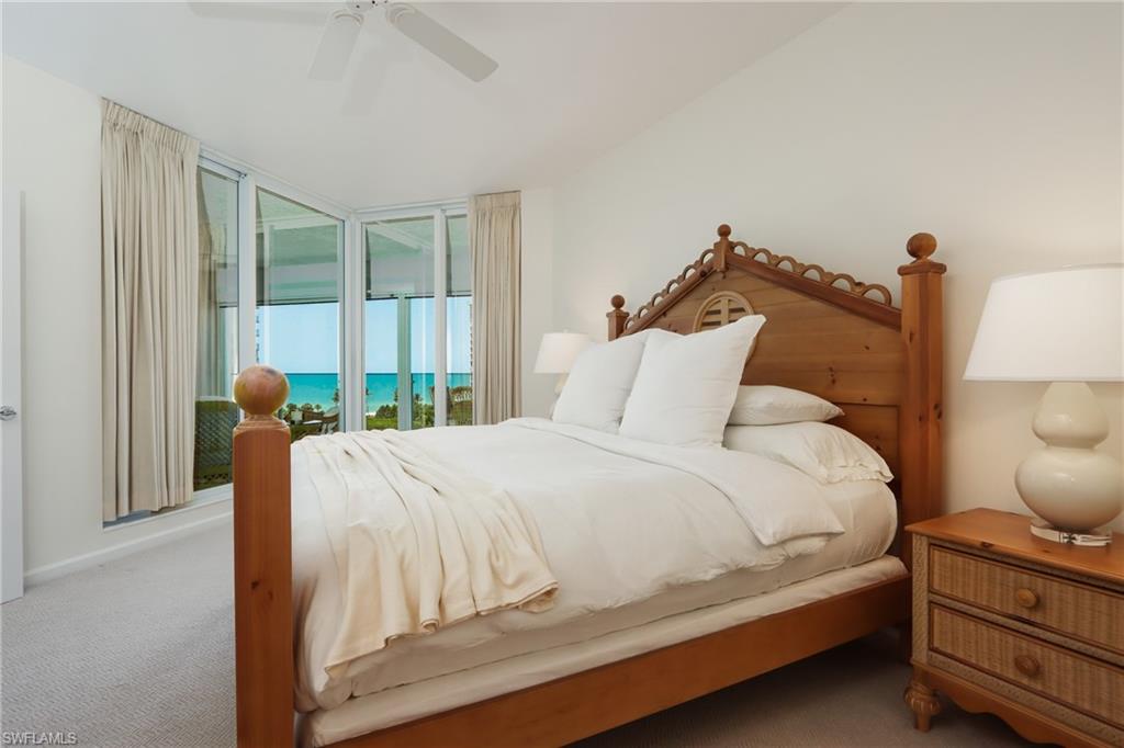 60 Seagate Drive, Unit 704 Naples, FL 34103 - Photo 13 of 28 a bedroom with a bed and large window