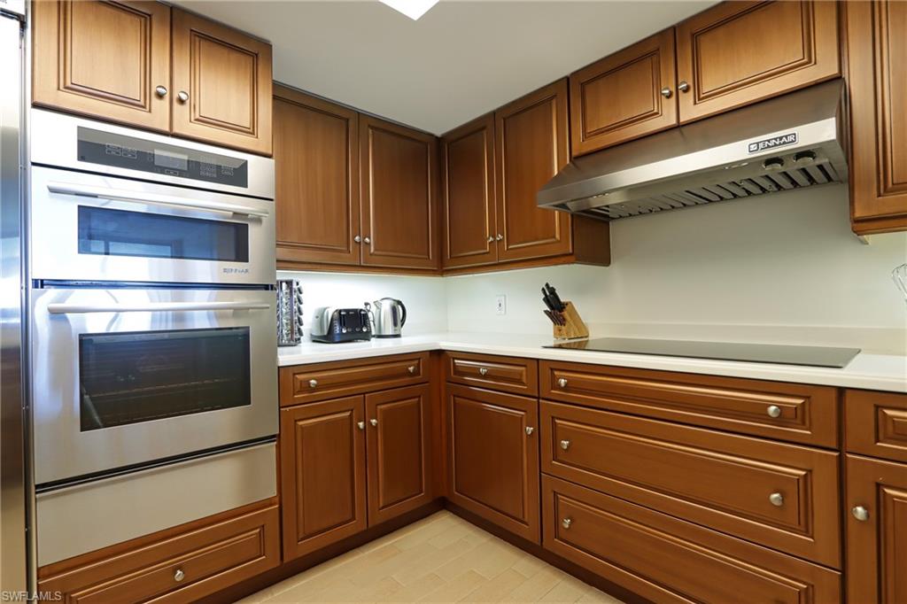 60 Seagate Drive, Unit 704 Naples, FL 34103 - Photo 9 of 28 a kitchen with granite countertop stainless steel appliances and cabinets