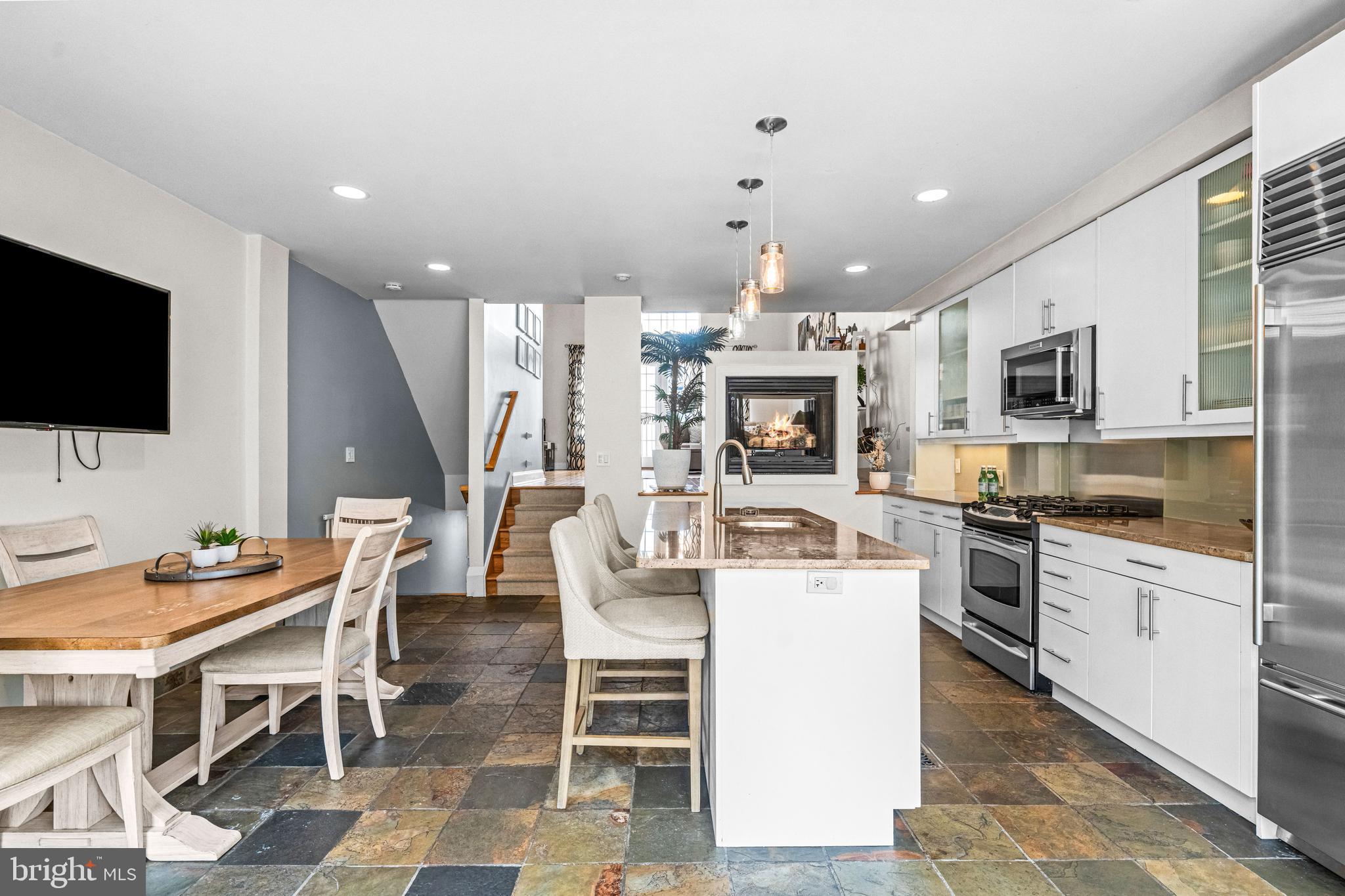 116 Quarry Street Philadelphia, PA 19106 - Photo 22 of 57 a kitchen with stainless steel appliances kitchen island granite countertop a stove top oven a sink a dining table and chairs