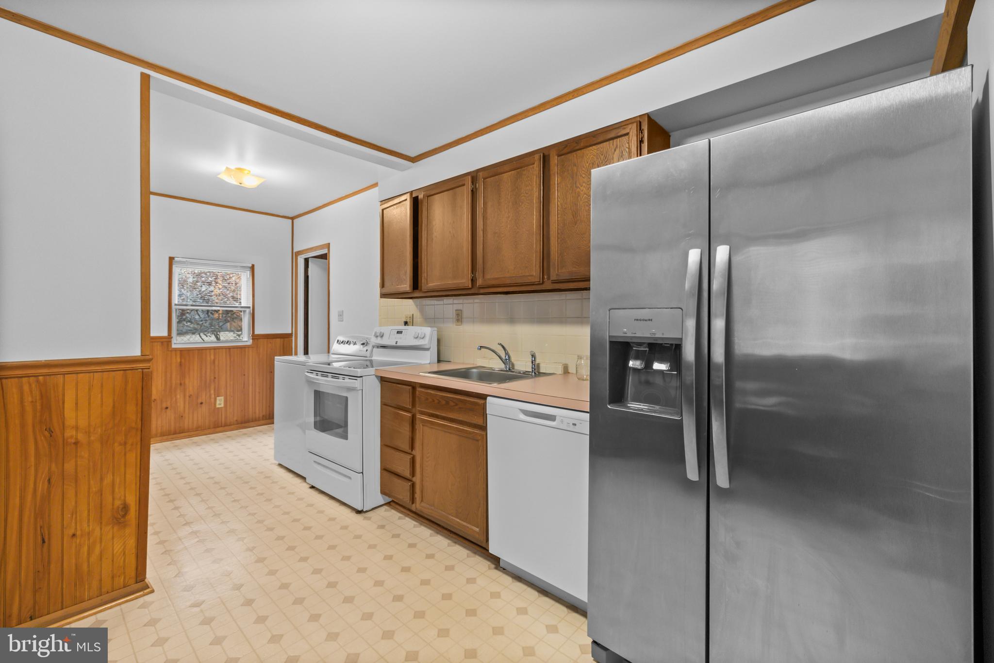 4 Russell Road Cabin John, MD 20818 - Photo 12 of 56 a kitchen with stainless steel appliances granite countertop a refrigerator a sink and white cabinets