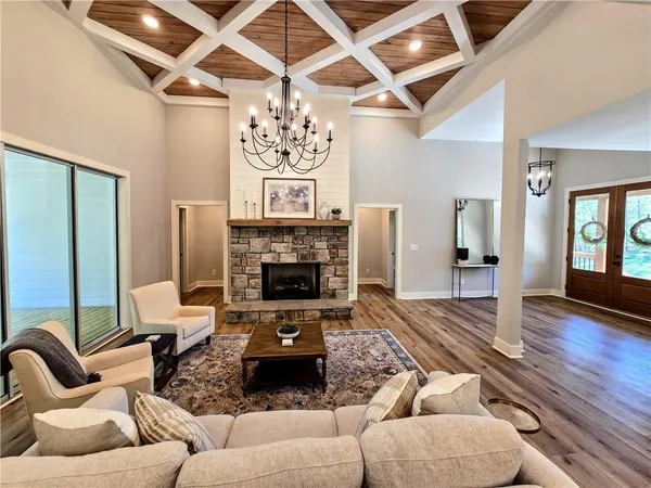 an empty room with windows and chandelier fan