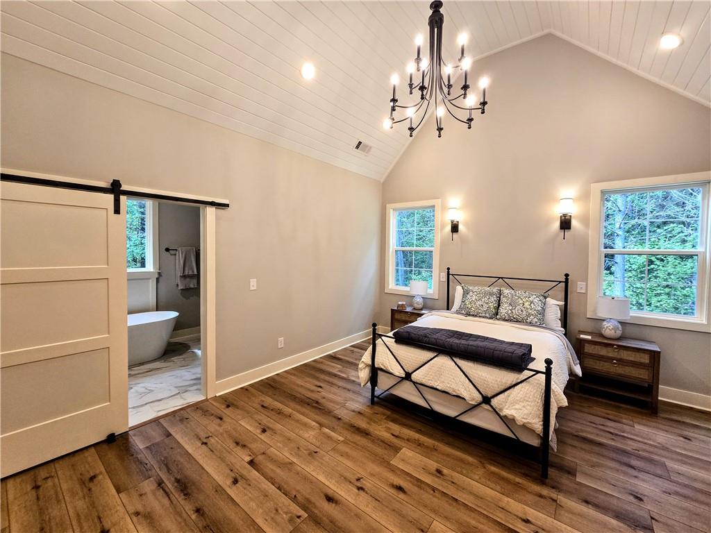 136 Rainey Road Temple, GA 30179 - Photo 34 of 75 a spacious bedroom with a bed and wooden floor