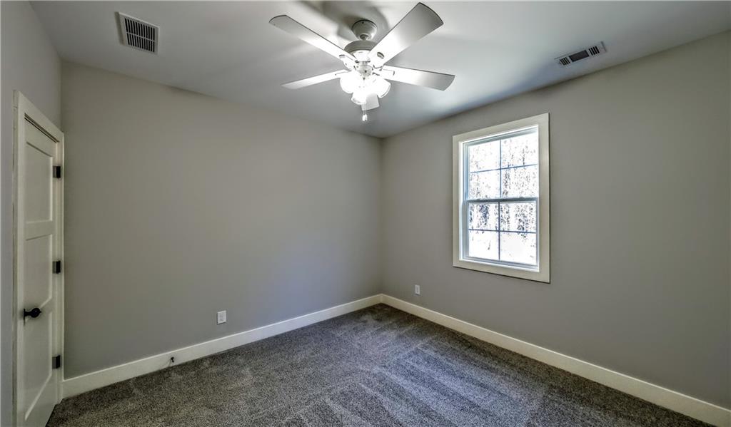 136 Rainey Road Temple, GA 30179 - Photo 58 of 75 an empty room with windows and chandelier fan