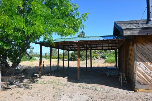 a view of a backyard with floor to ceiling window and wooden floor