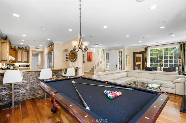 a living room with stainless steel appliances furniture a rug and a view of kitchen