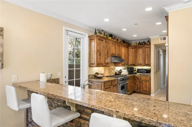 a kitchen with stainless steel appliances kitchen island granite countertop a sink and cabinets