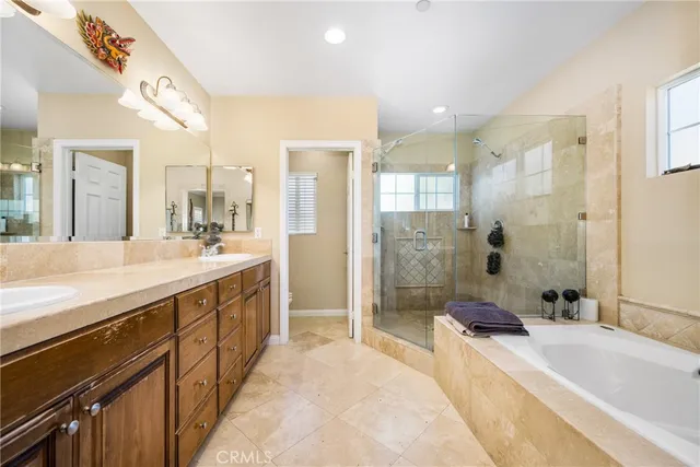 a spacious bathroom with a shower sink double vanity and a bathtub