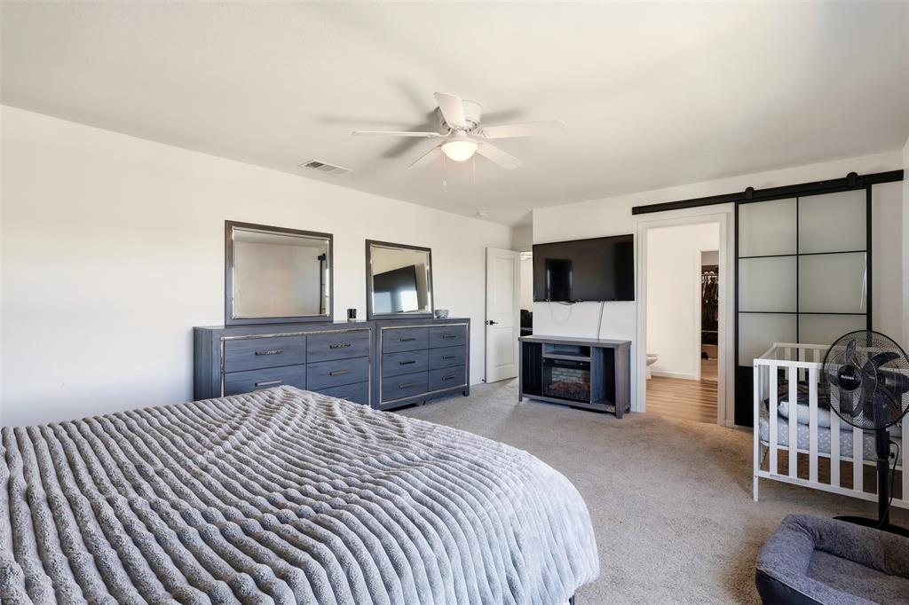 791 Devonshire Drive Lavon, TX 75166 - Photo 17 of 32 a spacious bedroom with a bed and a television in it