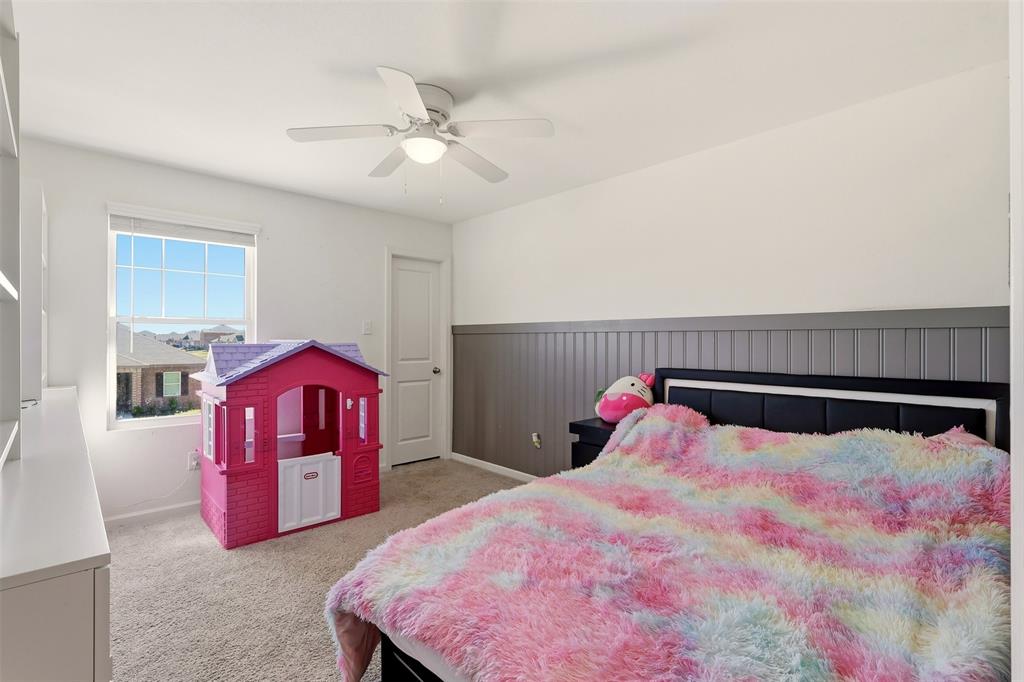 791 Devonshire Drive Lavon, TX 75166 - Photo 23 of 32 a bedroom with a bed and a chandelier