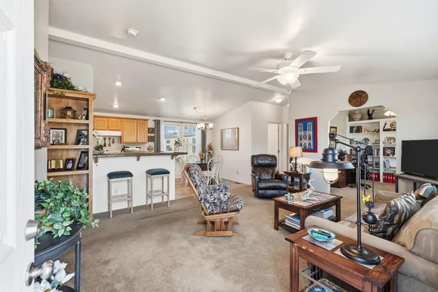 a living room with furniture a fireplace and kitchen view