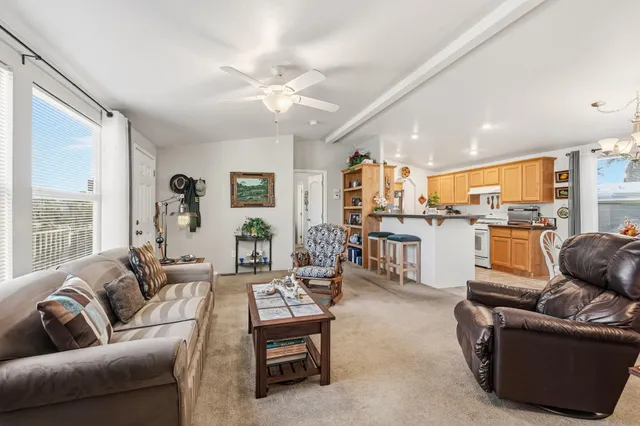a living room with furniture kitchen and a large window