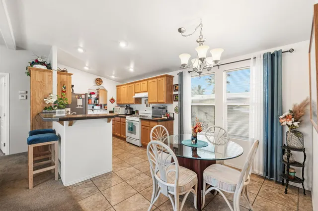a dining room filled chandelier and kitchen view