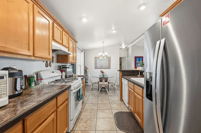 a kitchen with stainless steel appliances granite countertop a sink refrigerator and cabinets