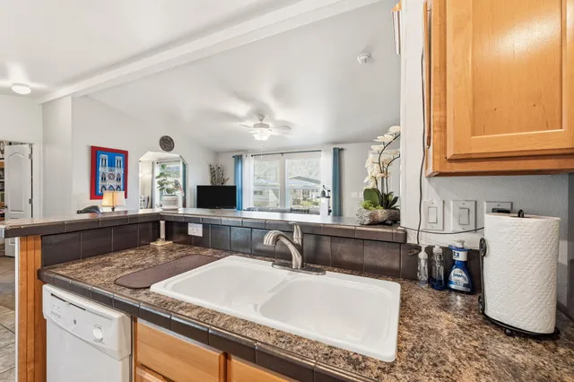 a living room with stainless steel appliances kitchen island granite countertop furniture and a large window