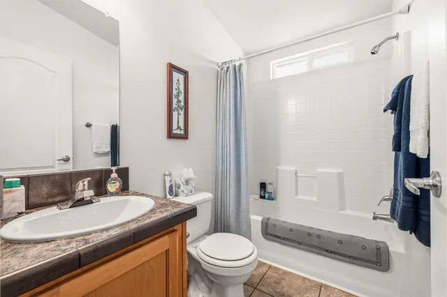 a bathroom with a granite countertop sink toilet and a mirror