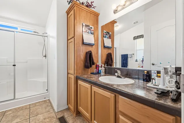 a bathroom with a double vanity sink mirror and shower