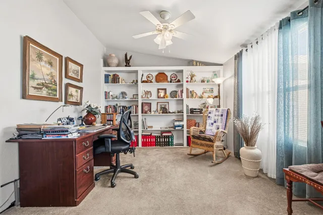 a view of a workspace with furniture and a window