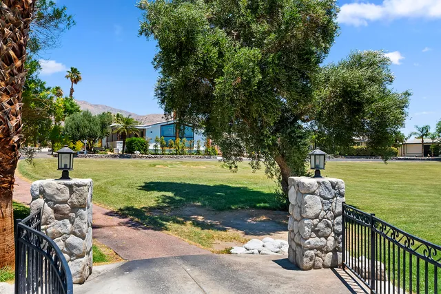 an aerial view of a house with a garden and lake view