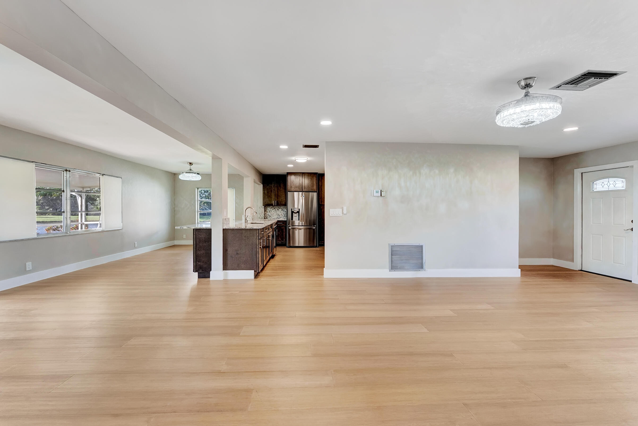 14263 El Clavel Way Delray Beach, FL 33484 - Photo 14 of 39 a view of an empty room with wooden floor and a kitchen