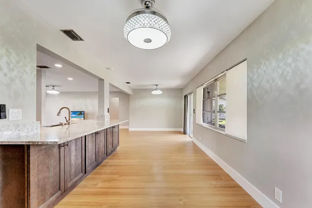 a kitchen with stainless steel appliances granite countertop a sink a stove top oven a counter space and cabinets