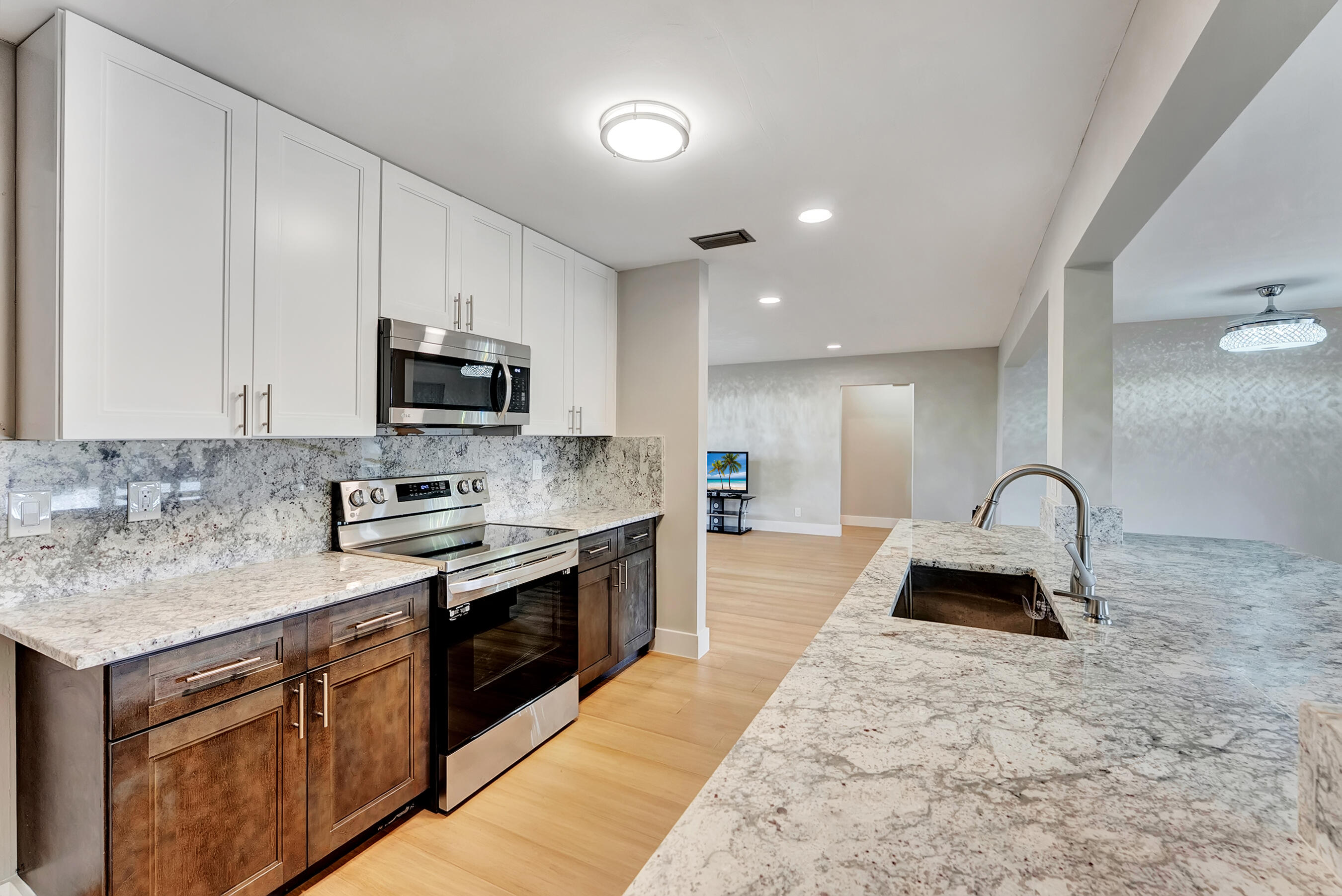 14263 El Clavel Way Delray Beach, FL 33484 - Photo 18 of 39 a kitchen with stainless steel appliances granite countertop a sink a stove top oven a counter space and cabinets