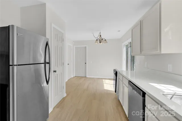 a view of a kitchen with a refrigerator and cabinets