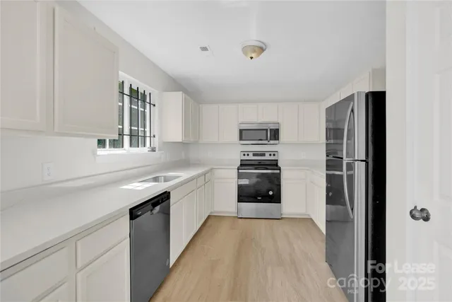 a kitchen with stainless steel appliances a refrigerator sink and cabinets