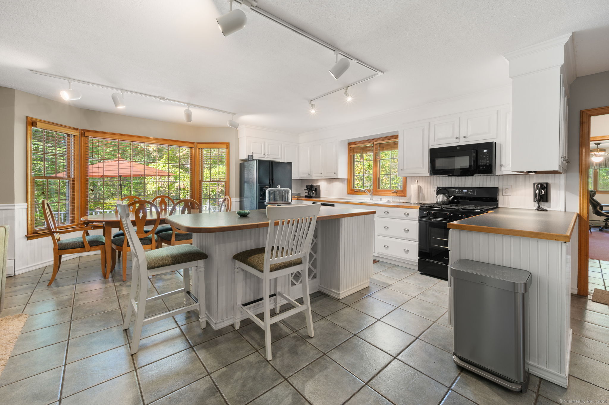 383 Lathrop Road Plainfield, CT 06374 - Photo 11 of 40 a kitchen with stainless steel appliances granite countertop a stove top oven a sink dishwasher a dining table and chairs with wooden floor