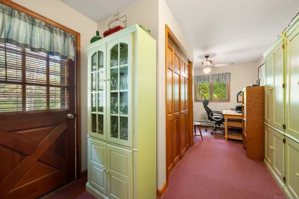 a view of a workspace with furniture and a window