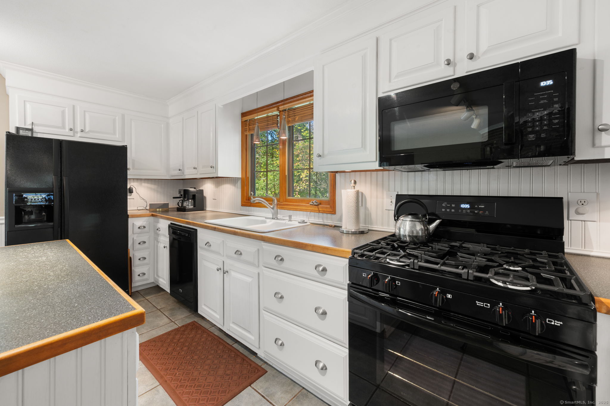 383 Lathrop Road Plainfield, CT 06374 - Photo 15 of 40 a kitchen with stainless steel appliances a stove a microwave a sink and cabinets