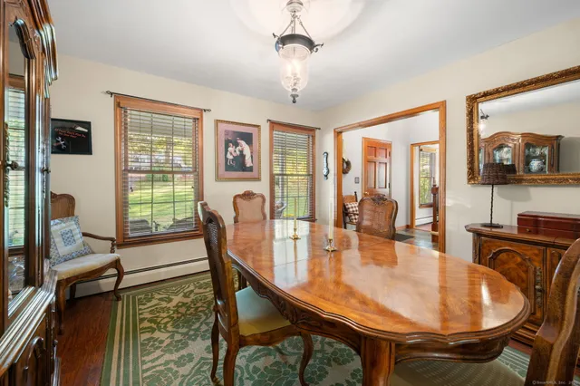 a dining room with furniture a chandelier and wooden floor