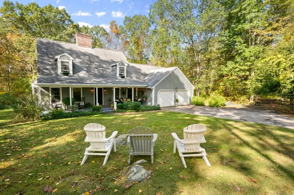 a view of a house with a yard chairs and table in patio