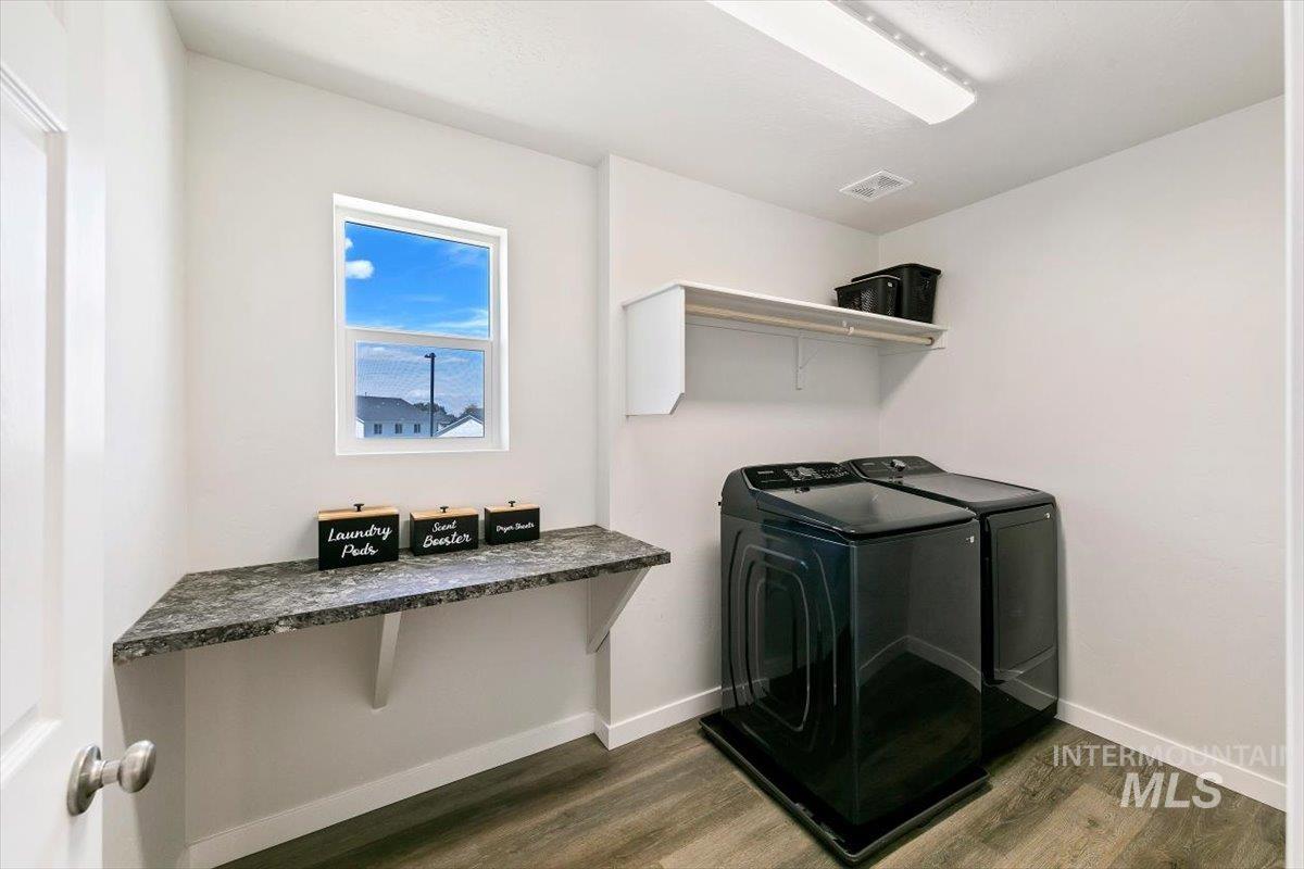 8575 South Foraker Way Kuna, ID 83634 - Photo 23 of 43 Upstairs light-filled laundry room featuring a window, built-in shelving, and a countertop for folding