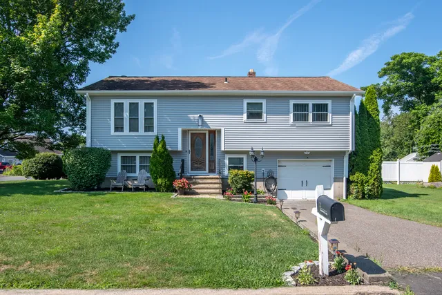a front view of a house with a garden and plants