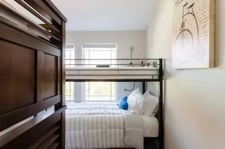 a bedroom with a bed and large windows
