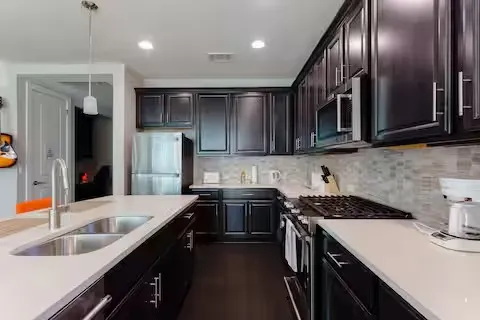 a kitchen with stainless steel appliances granite countertop a sink stove and refrigerator