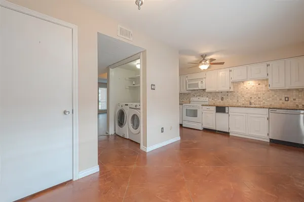 a view of a kitchen with white cabinets and white appliances