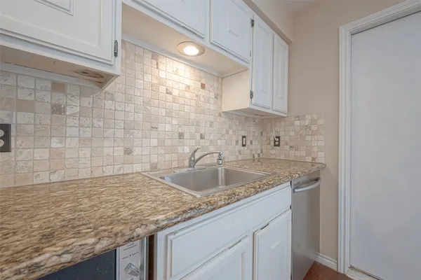 a kitchen with granite countertop a sink and cabinets