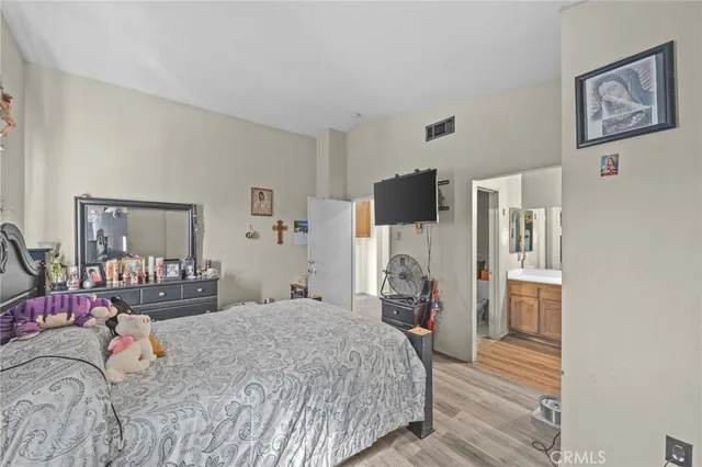 a bedroom with a bed and a refrigerator