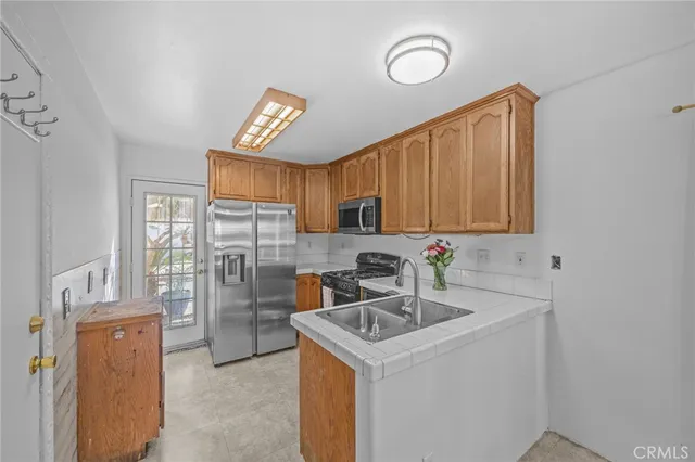 a kitchen with stainless steel appliances a sink cabinets and a refrigerator