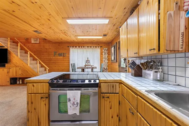 a kitchen with stainless steel appliances granite countertop a sink a stove and cabinets