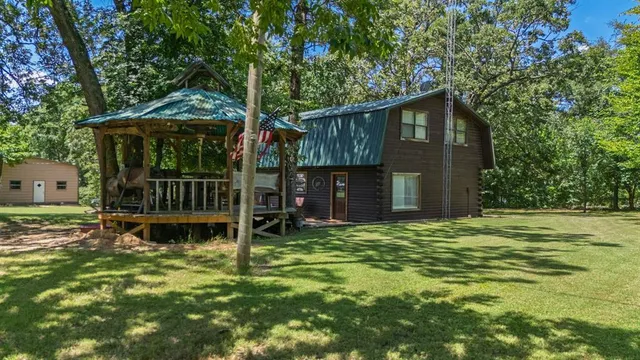 a backyard of a house with deck and outdoor seating