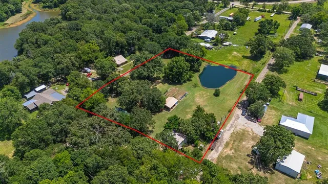 an aerial view of residential house with outdoor space and trees all around