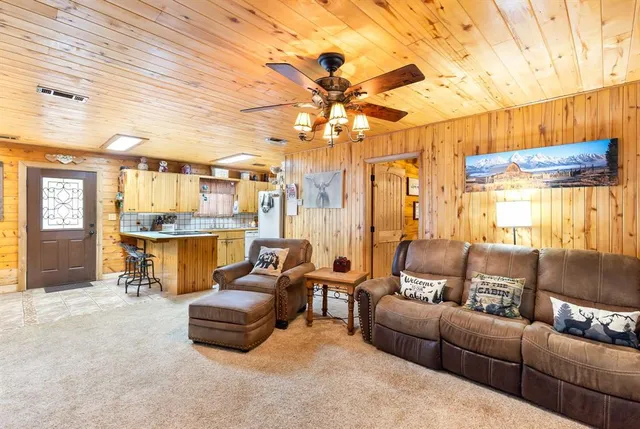 a living room with furniture a chandelier and a dining table