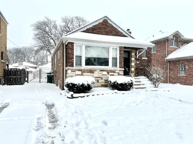 a view of a house with a yard covered in snow